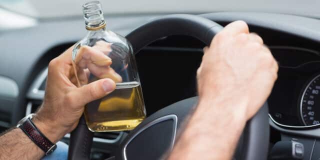 Man drinking alcohol while driving