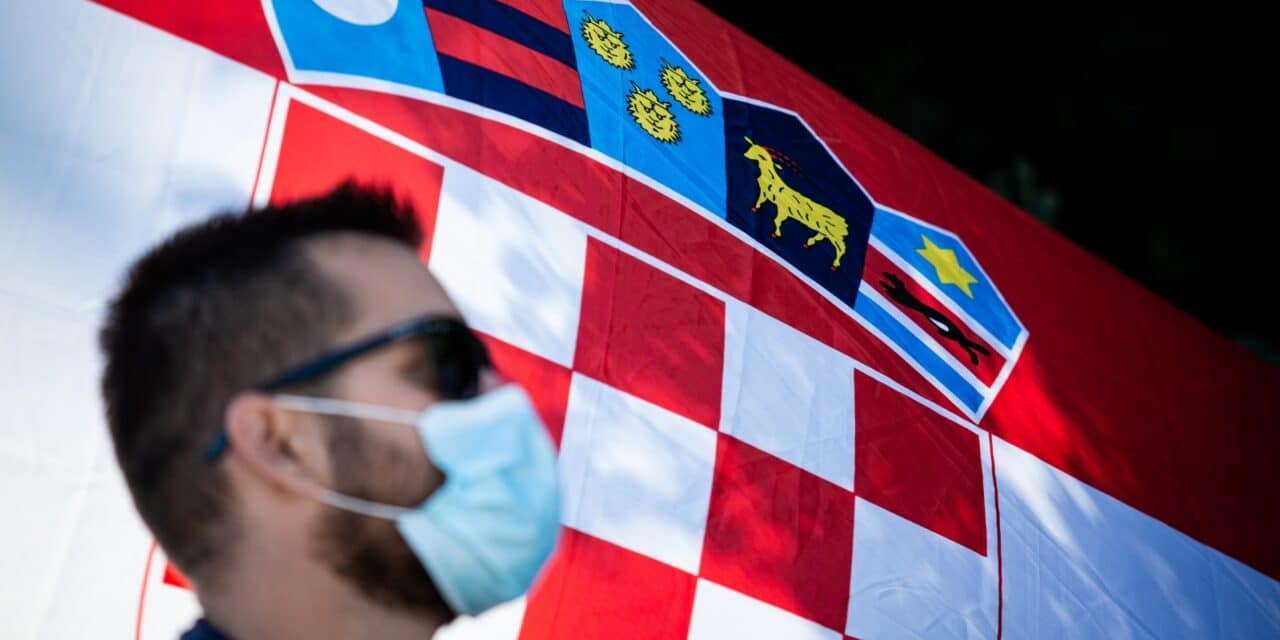 Ilustracija građana s maskom ispred hrvatske zastave