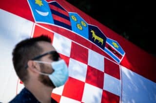 Ilustracija građana s maskom ispred hrvatske zastave