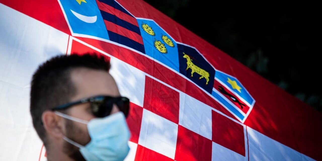 Ilustracija građana s maskom ispred hrvatske zastave