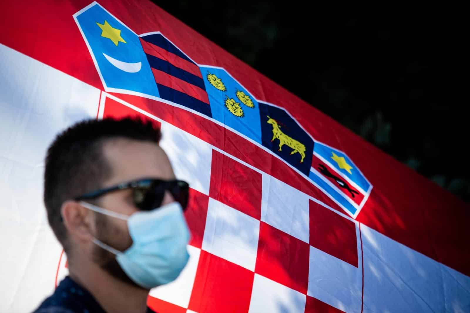 Ilustracija građana s maskom ispred hrvatske zastave
