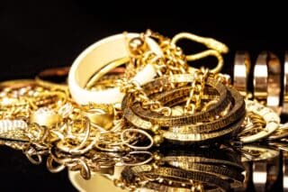 Bunch,Of,Gold,Jewelry,Against,Black,Background.