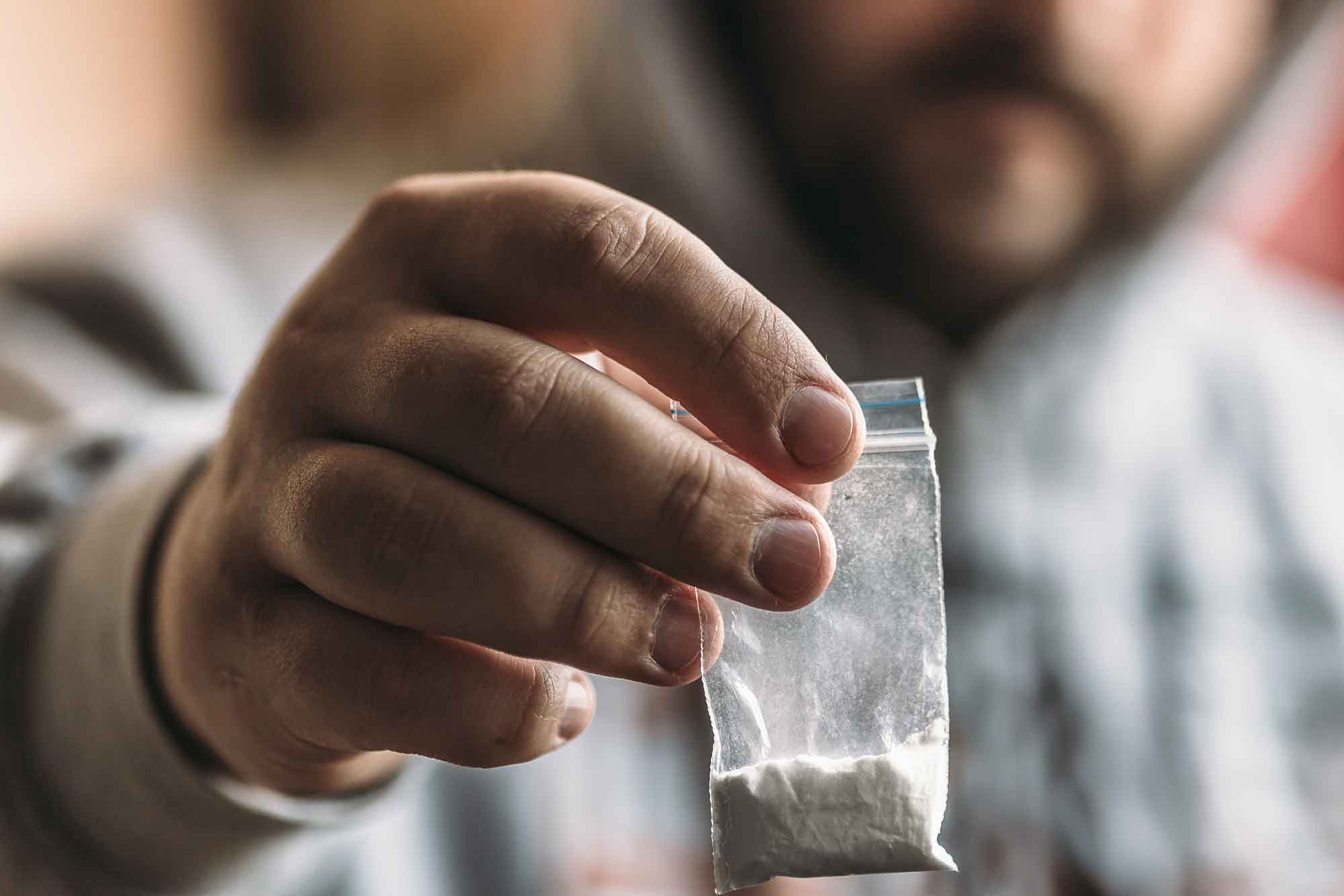 addict-holding-bag-of-heroin