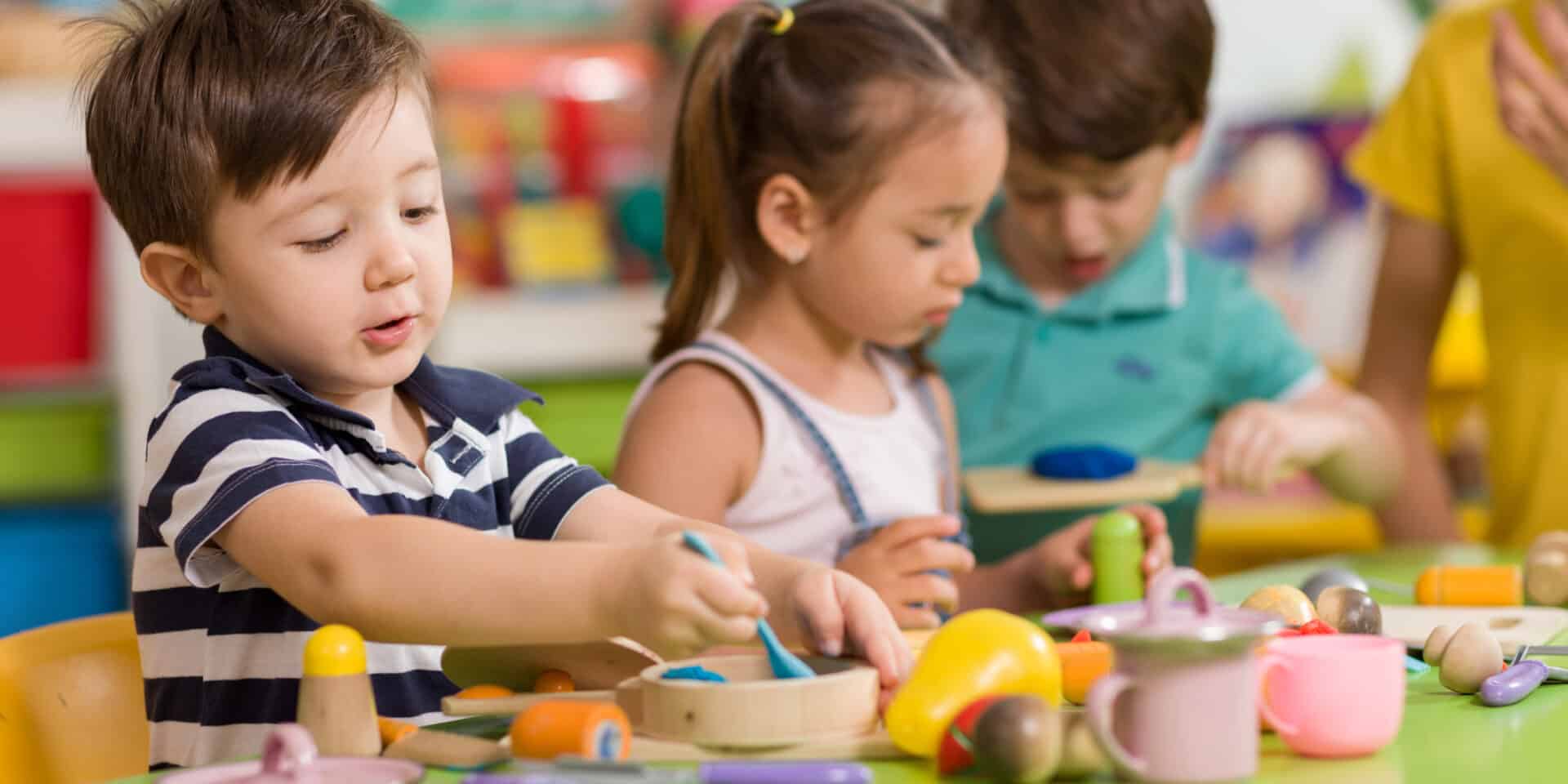 Childs are playing with play clay in classroom.