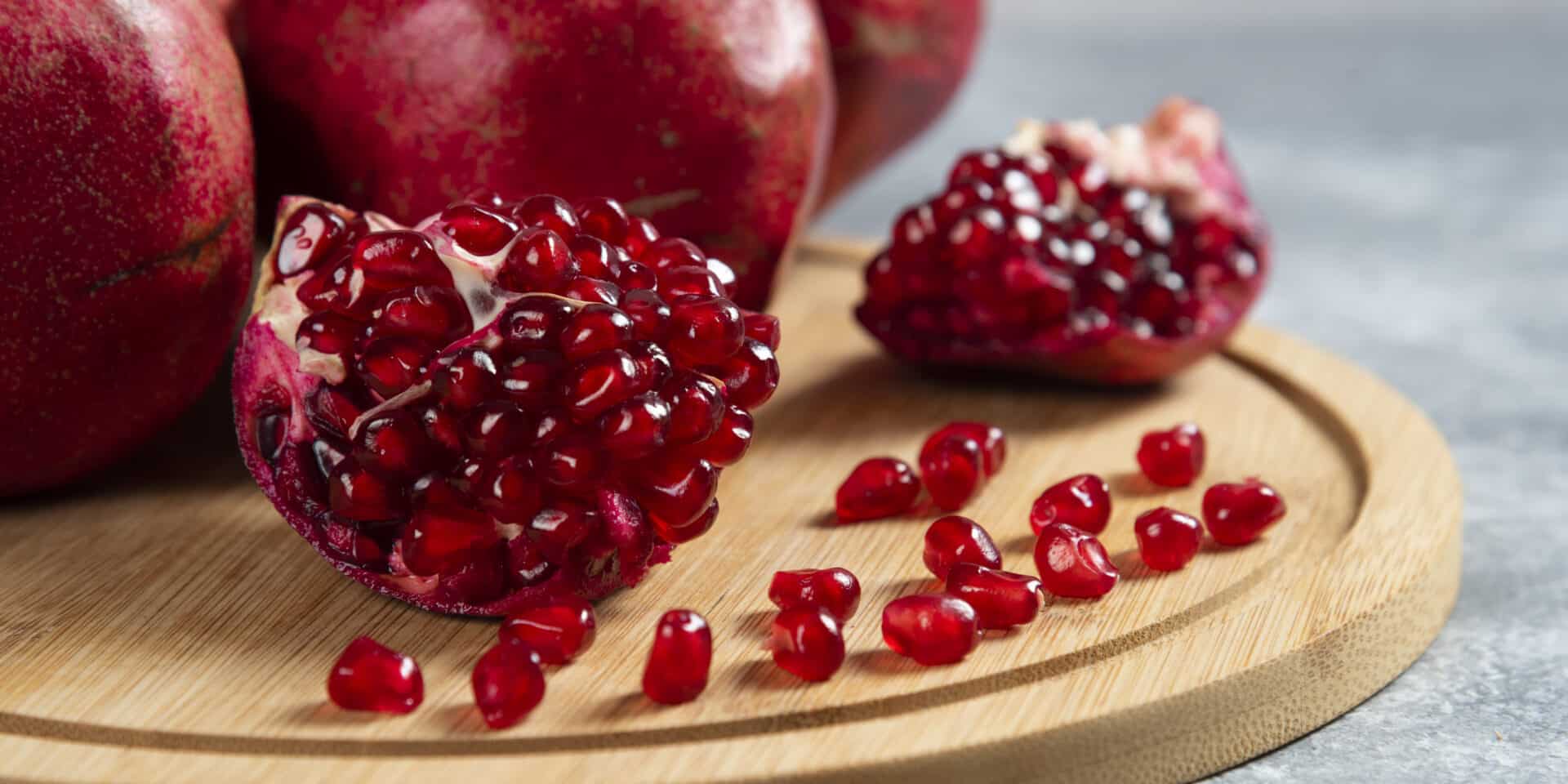 Sliced ripe pomegranate on a wooden board