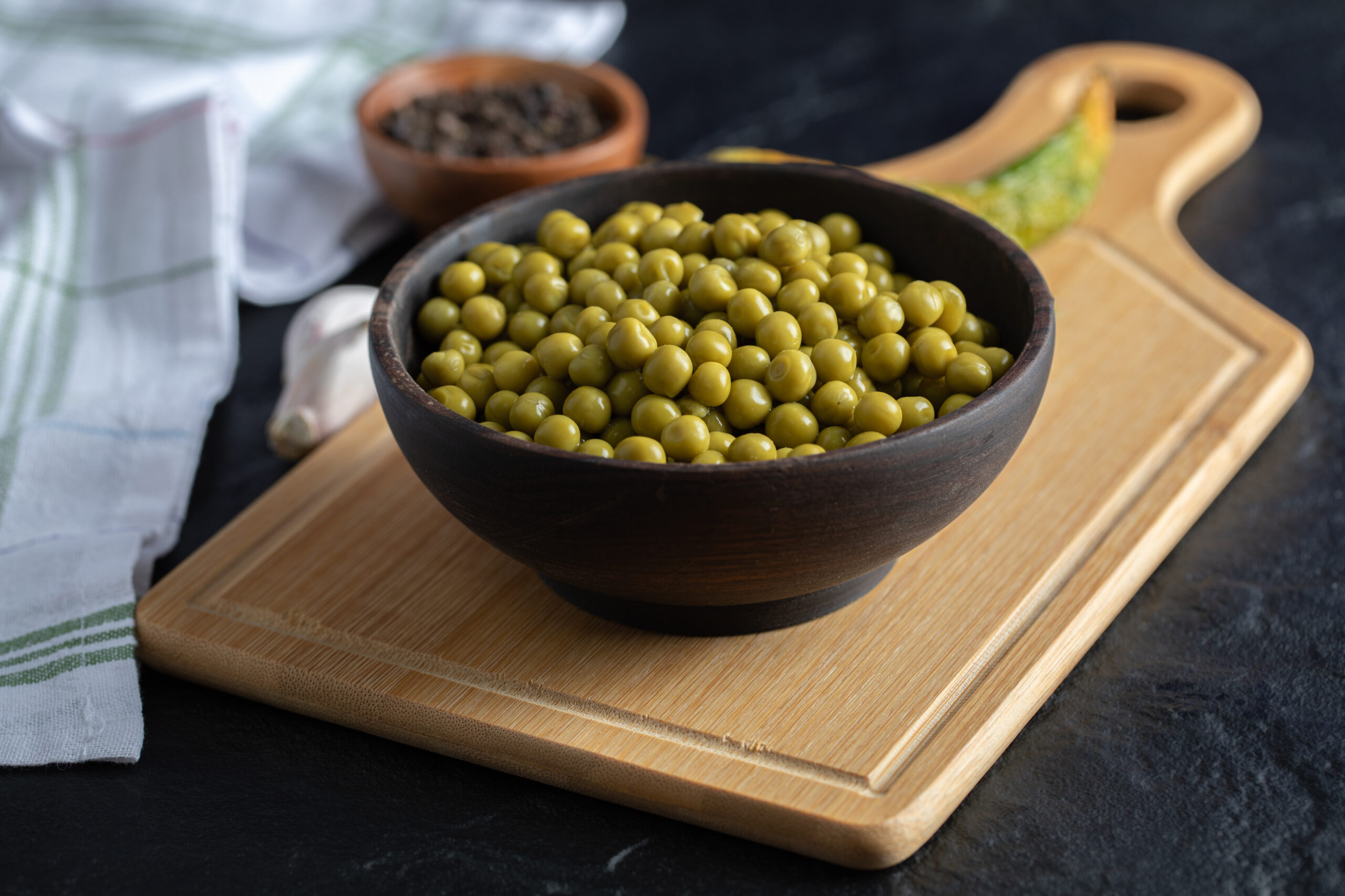 Bowl canned olives on wooden board