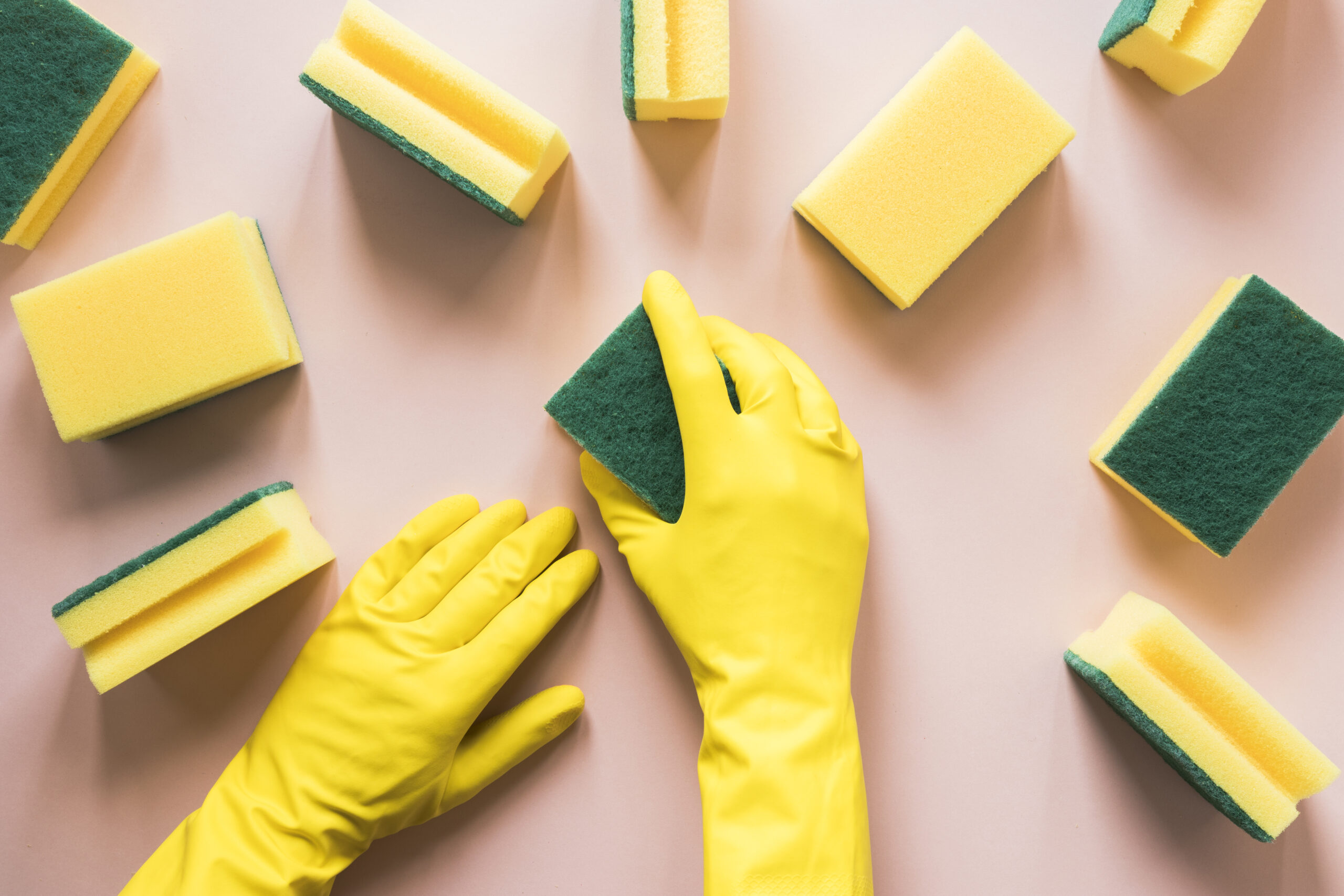 close-up-person-with-yellow-gloves-sponges