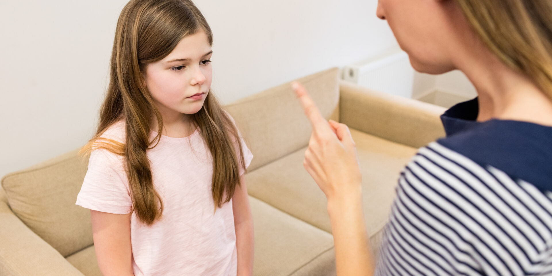 Mother scolding her daughter in living room