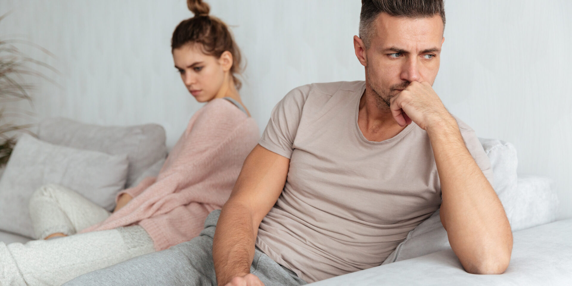 Image of Quarrelled lovely couple sitting separately on couch