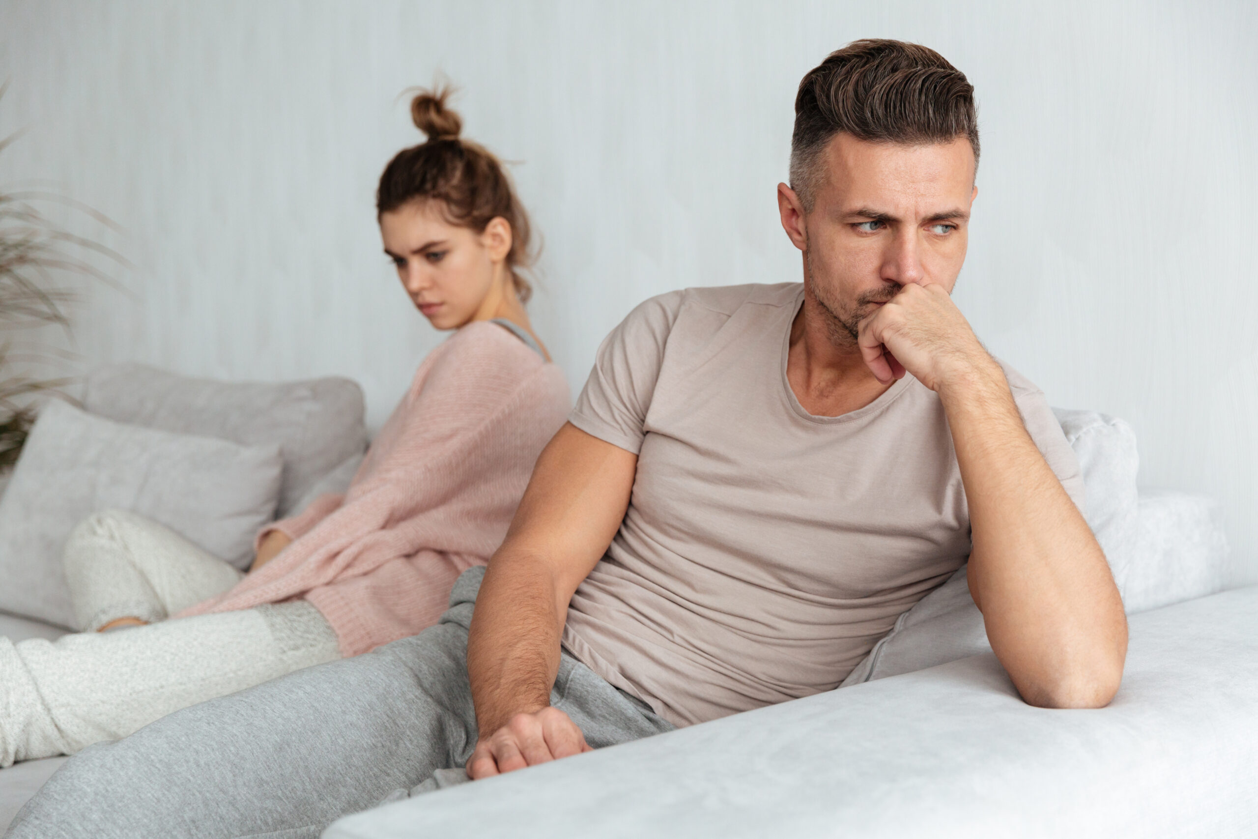Image of Quarrelled lovely couple sitting separately on couch