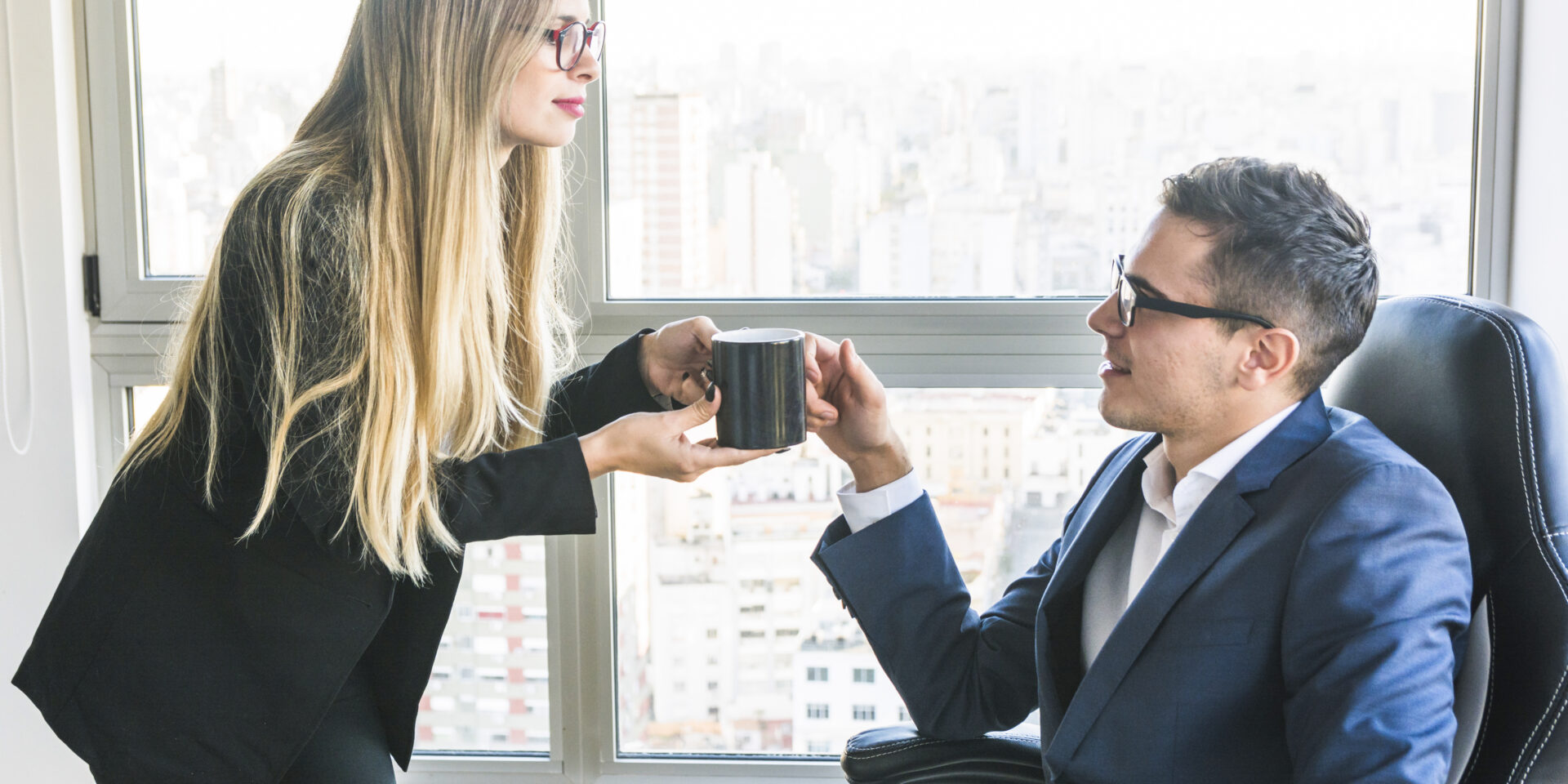 businesswoman-giving-coffee-her-boss-office