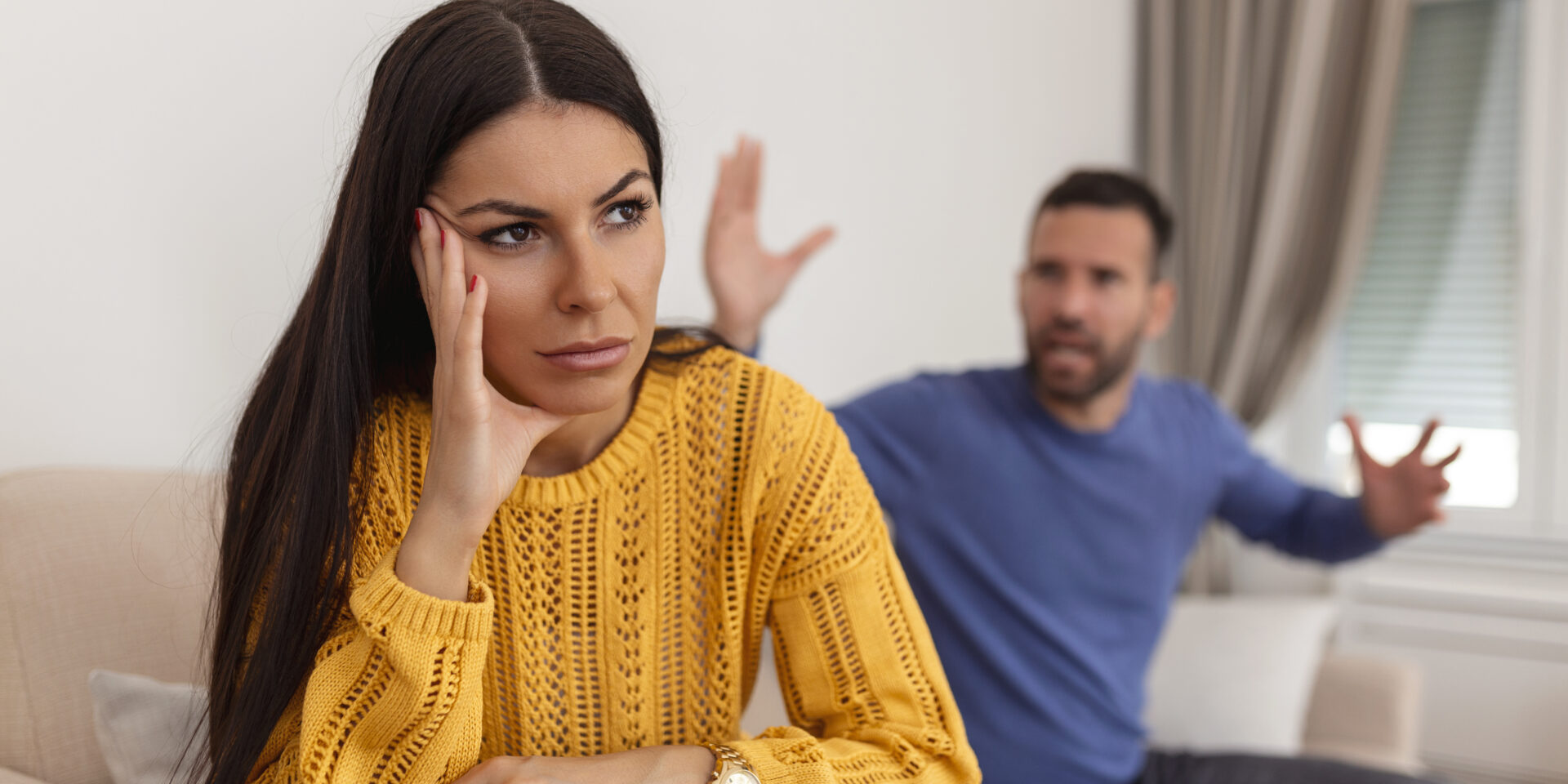 Young couple having argument – conflict, bad relationships. Angry fury woman. Angry young couple sit on couch in living room having family fight or quarrel suffer from misunderstanding