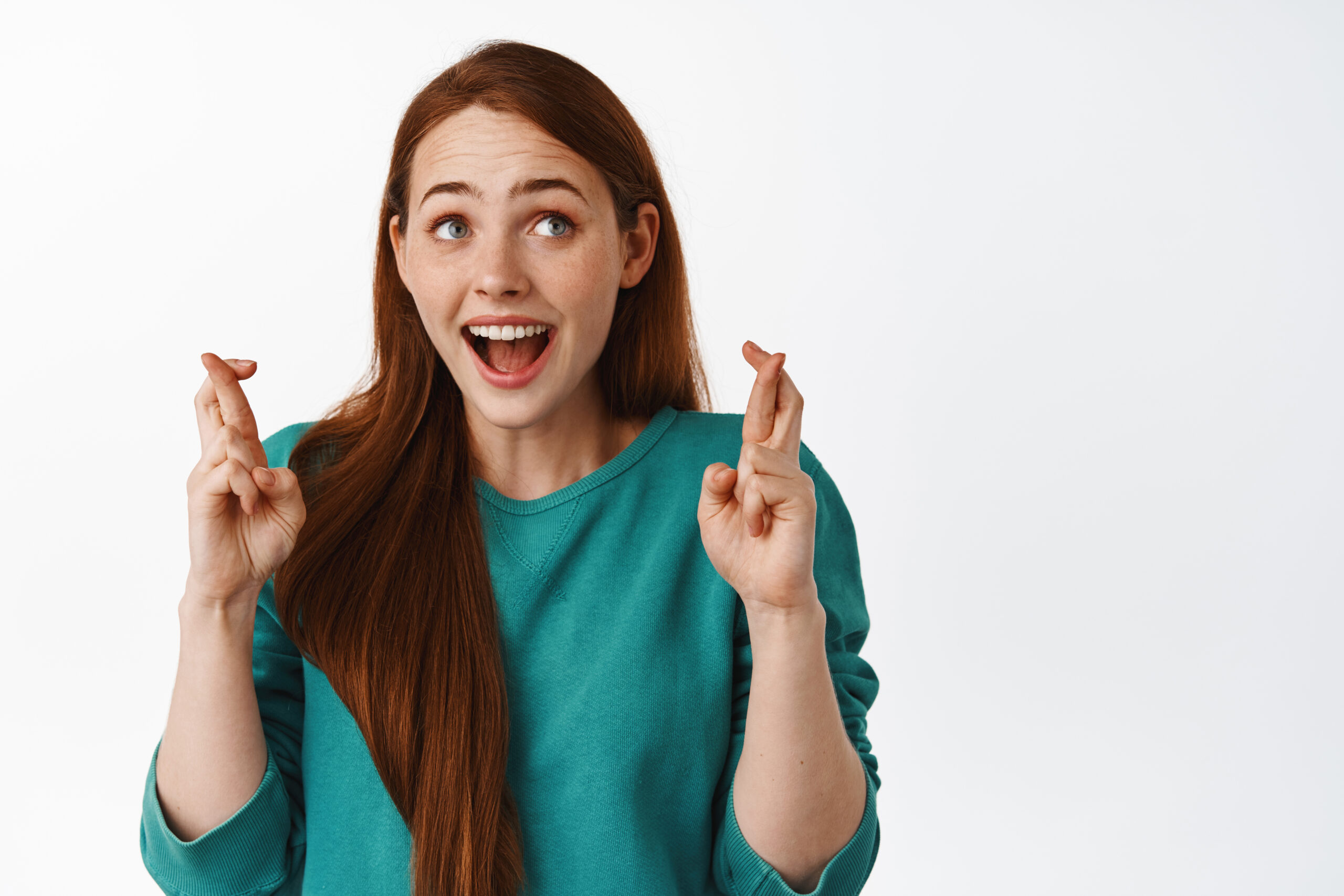 Hopeful redhead girl scream from excitement and cross fingers good luck, makes wish, anticipate positive results, waiting for news announcement, white background