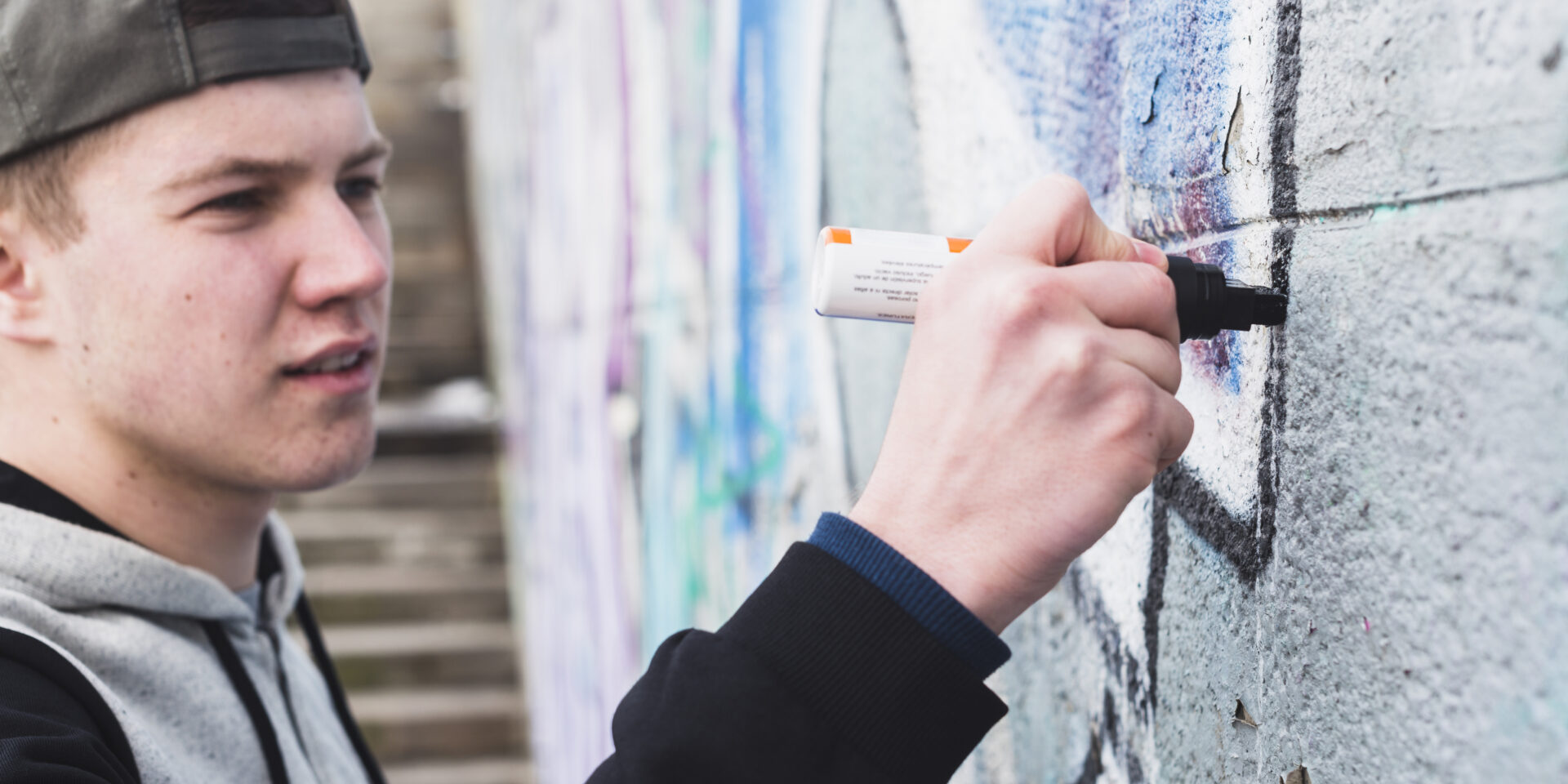 artist-making-outline-graffiti-wall