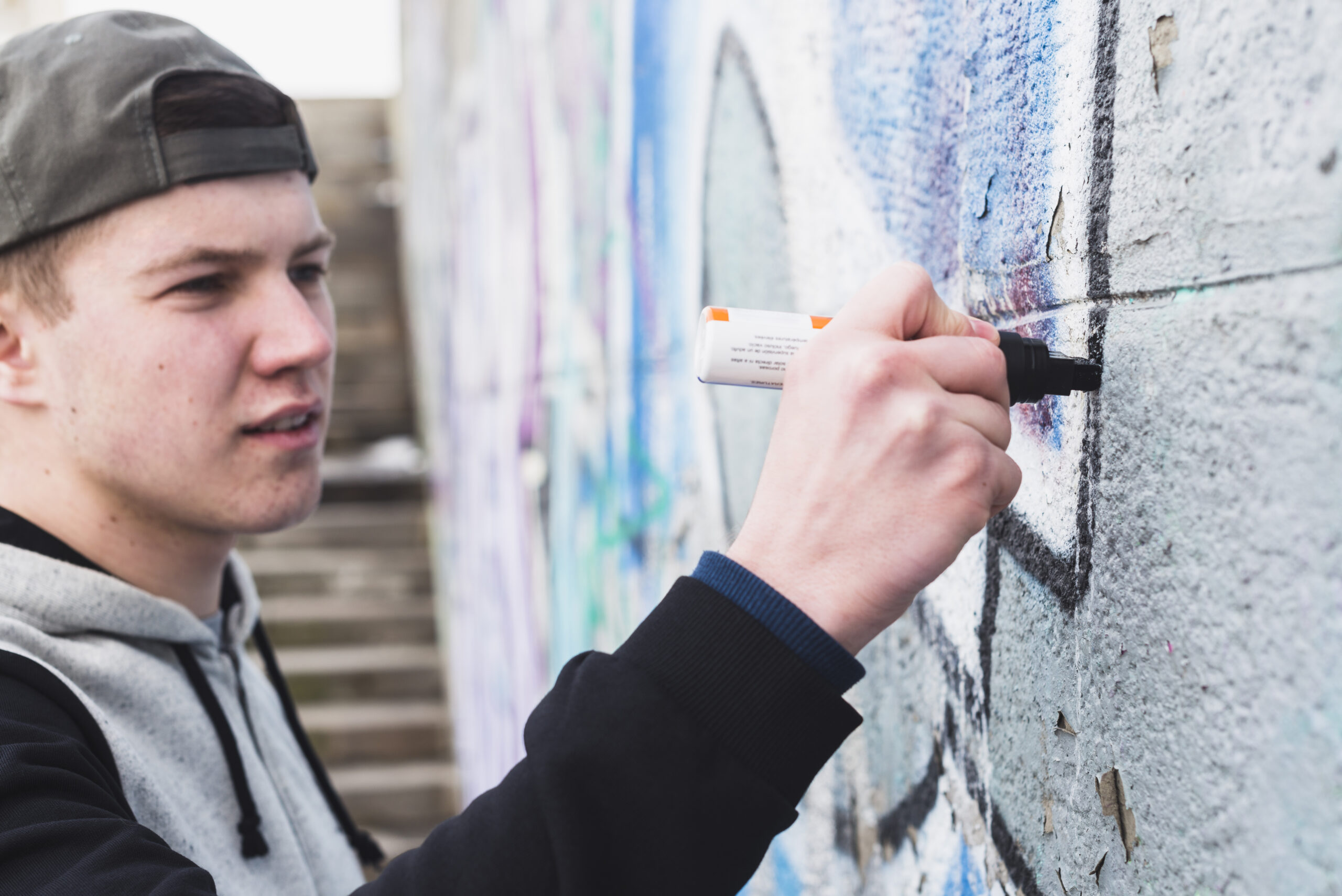 artist-making-outline-graffiti-wall