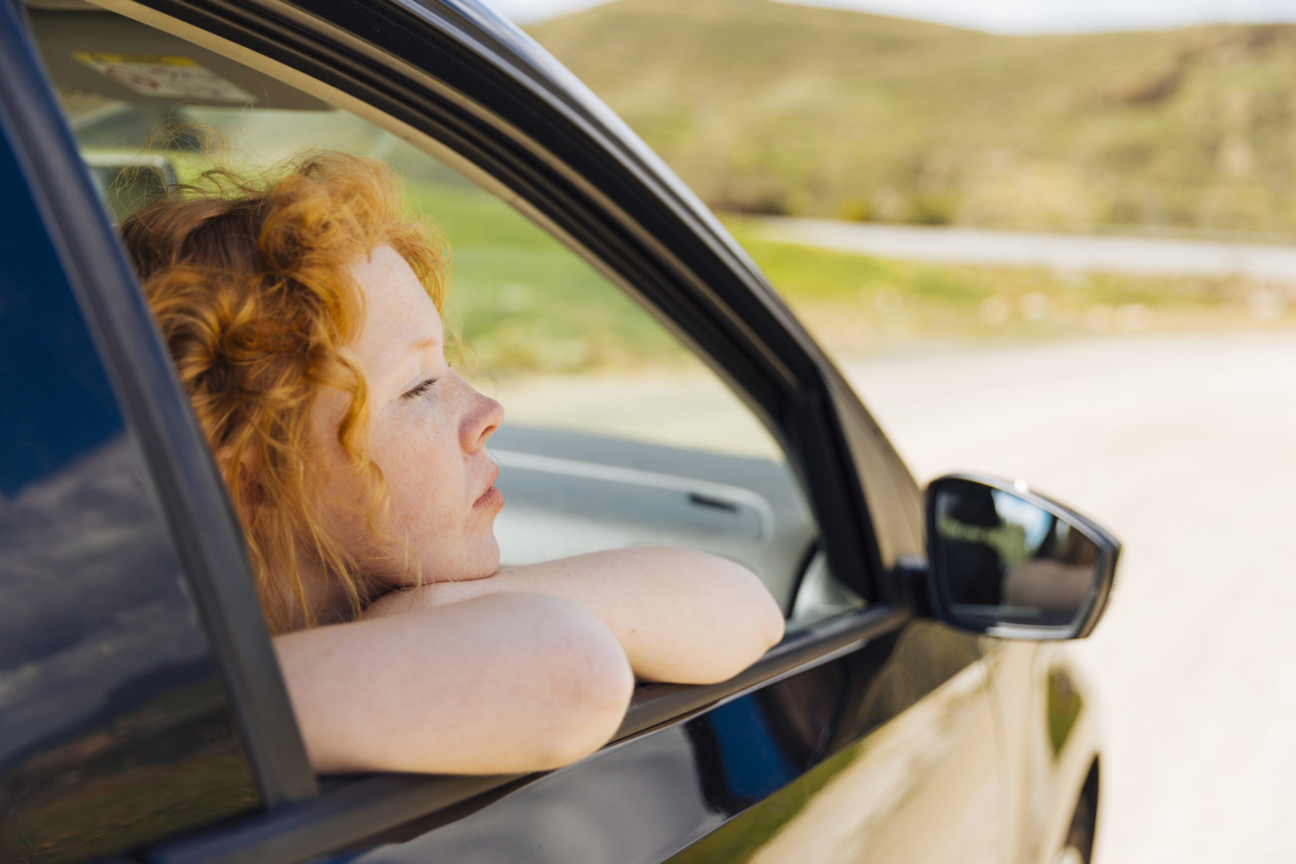 young-female-looking-out-car-window