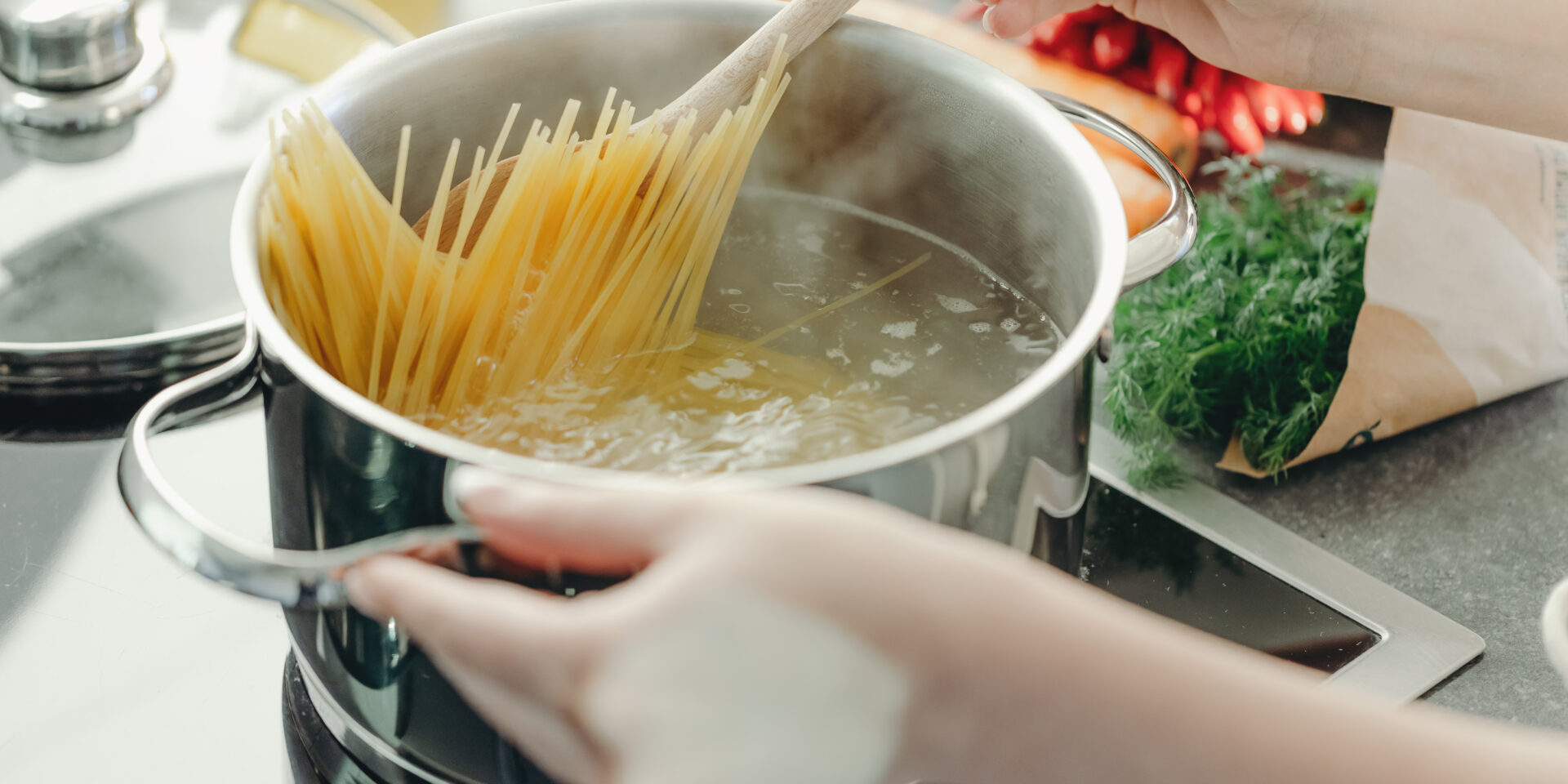Girl cooking pasta spaghetti in pot