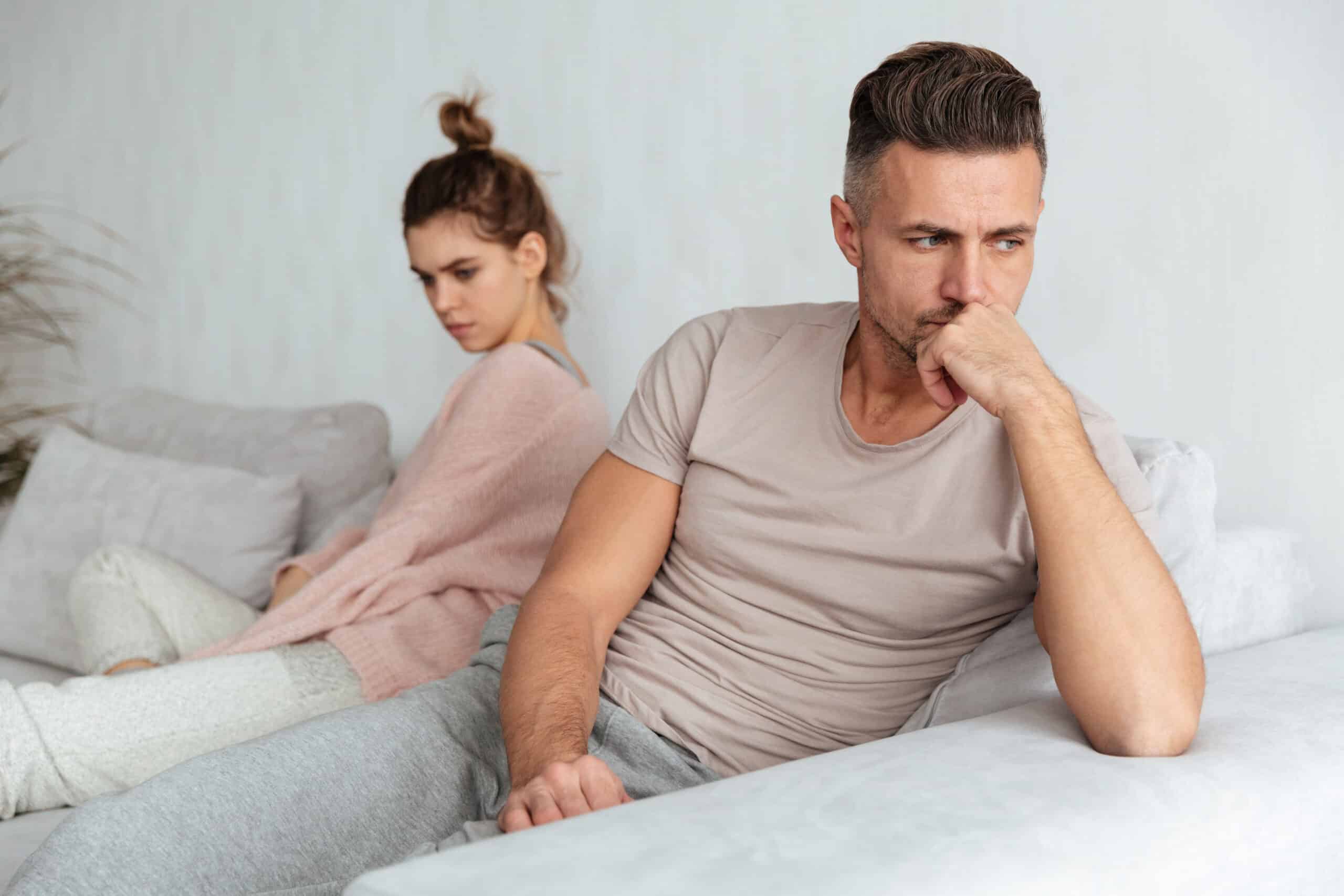 Image of Quarrelled lovely couple sitting separately on couch