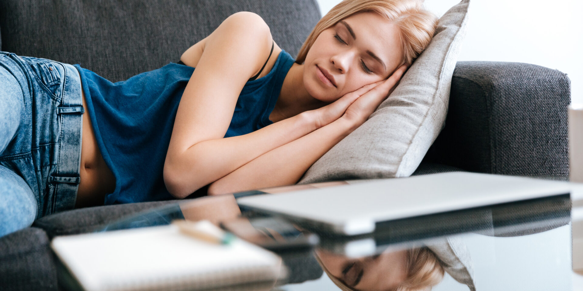 Woman lying and sleeping on couch at home