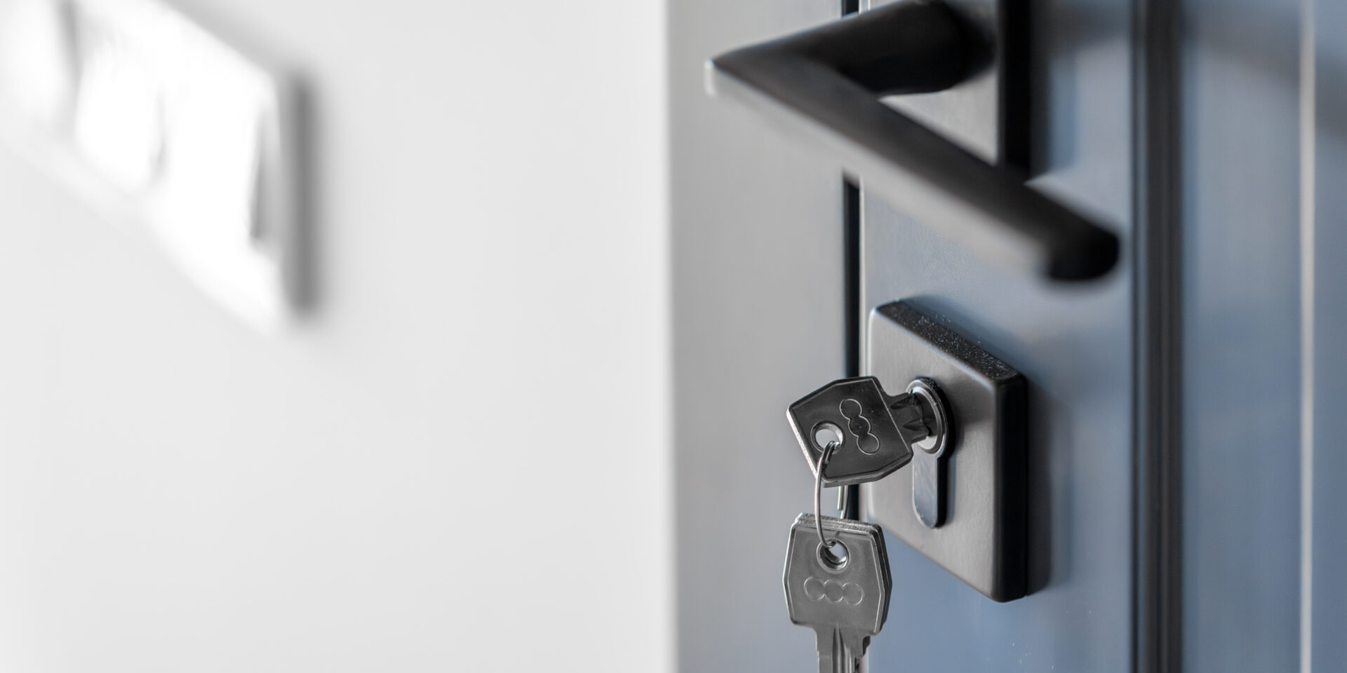 Keys in lock. Blue door panel. Clean space.