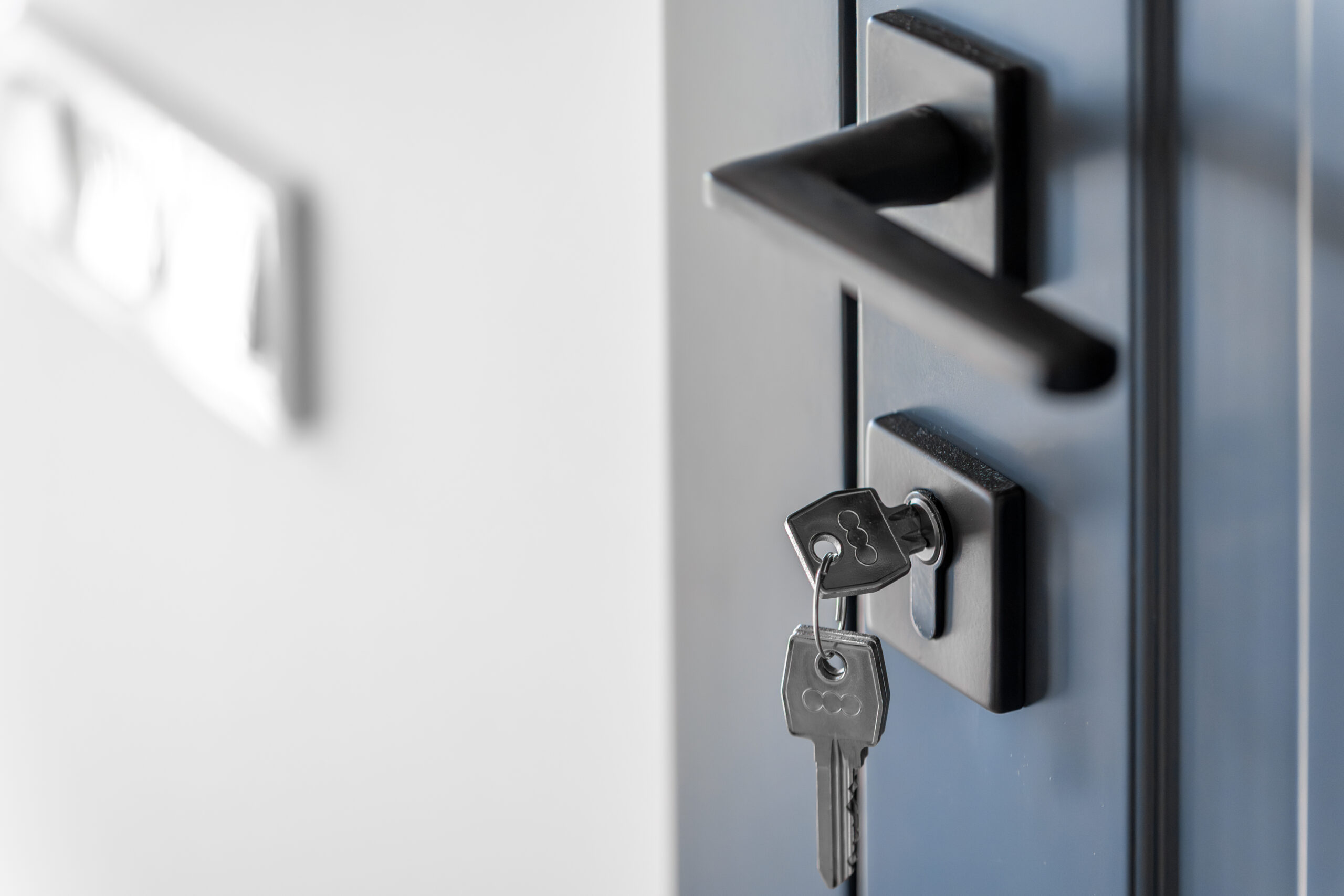 Keys in lock. Blue door panel. Clean space.