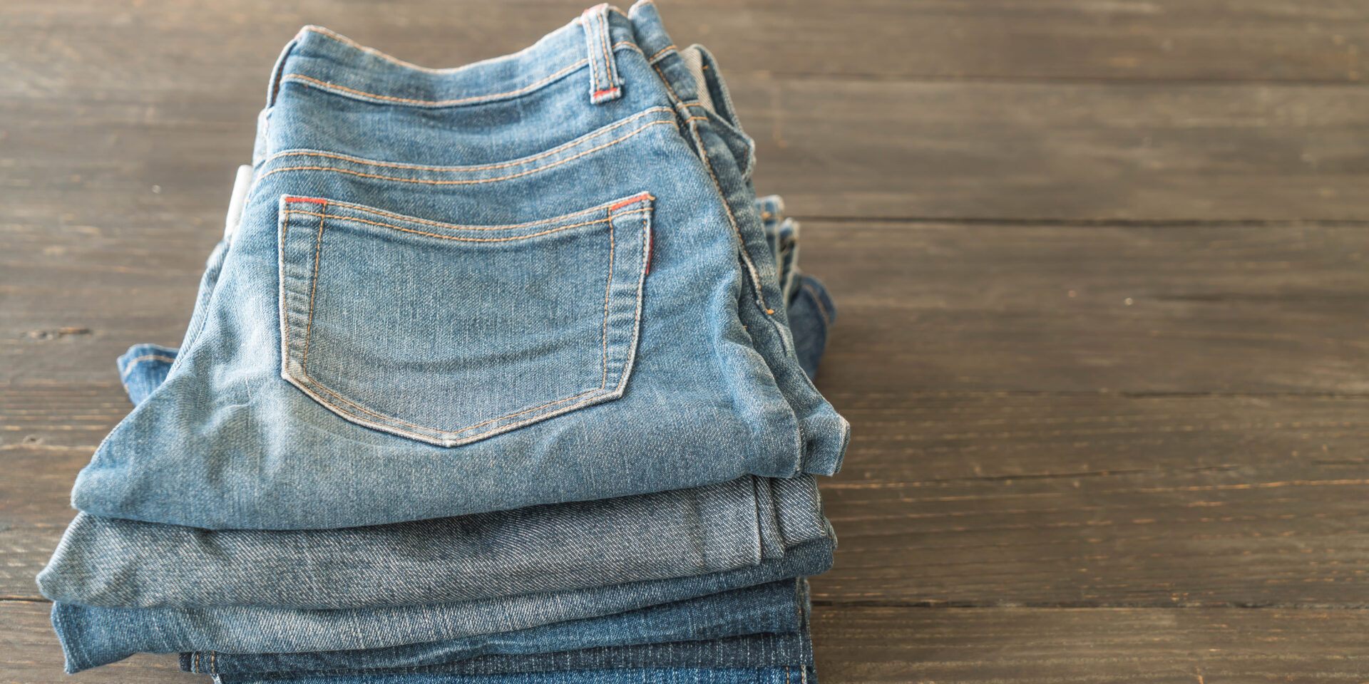 stacks of jeans clothing on wood