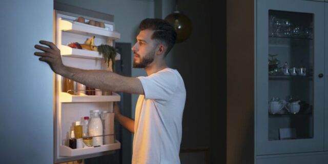 side-view-man-looking-snacks-fridge