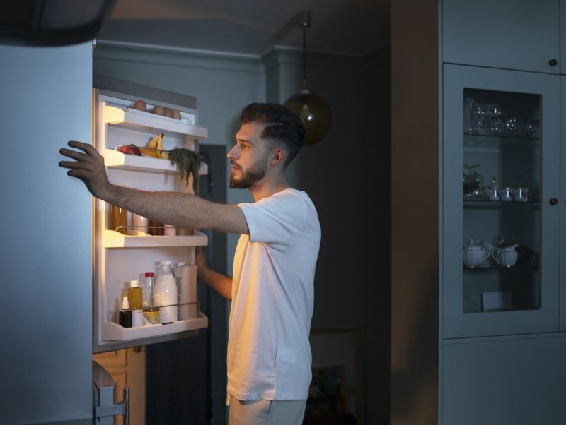 side-view-man-looking-snacks-fridge
